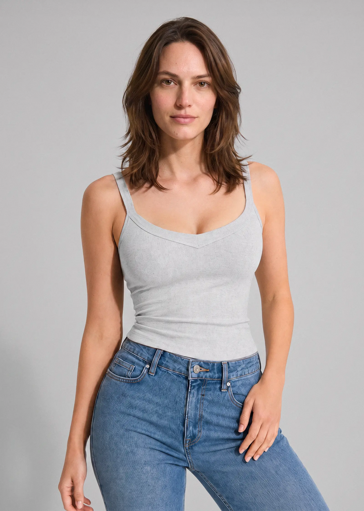 Femme portant un débardeur gris clair à soutien-gorge intégré sans armatures Onalie avec un jean bleu