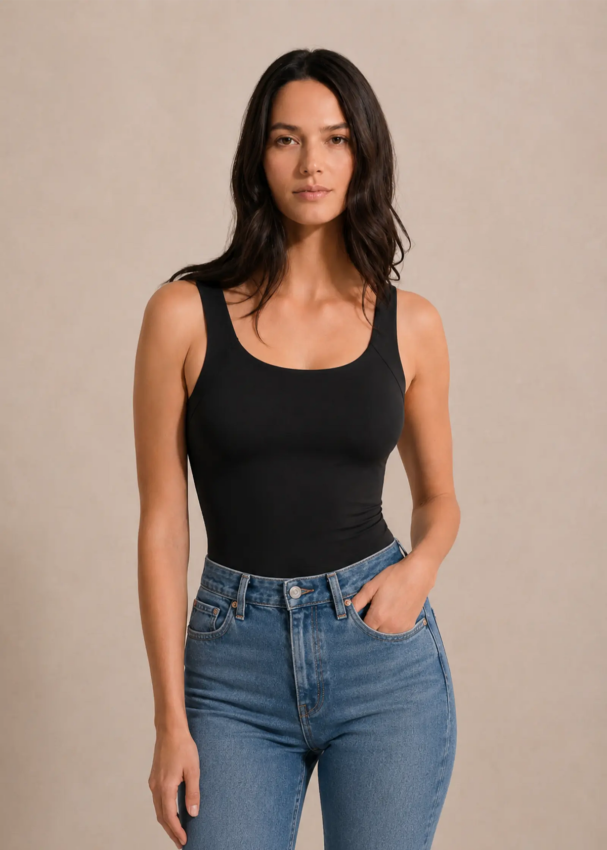 Femme portant le top sculptant effet seconde peau noir à brassière intégrée Onalie avec un jean bleu, vue de face