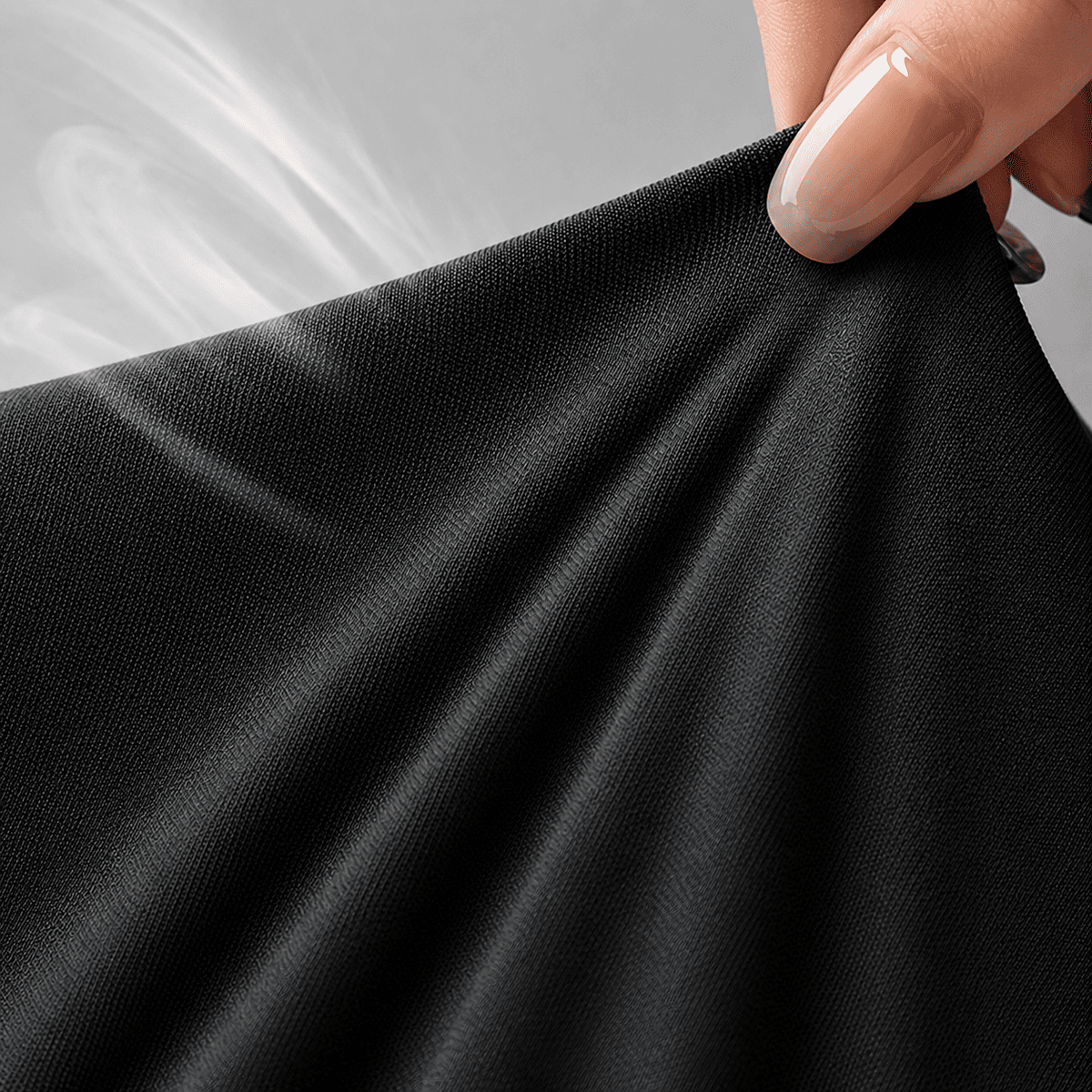 Main étirant la maille extensible et respirante du top noir sculptant Onalie.